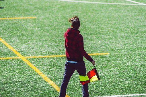 Sportveld van kunstgras met een persoon die een vlag vasthoudt