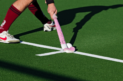 Man die hockey speelt op een kunstgras veld